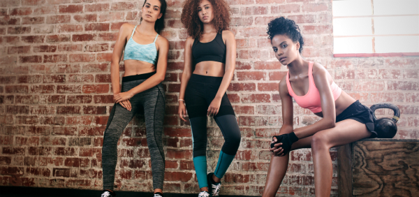 women standing together against a brick wall in a group workout for motivation