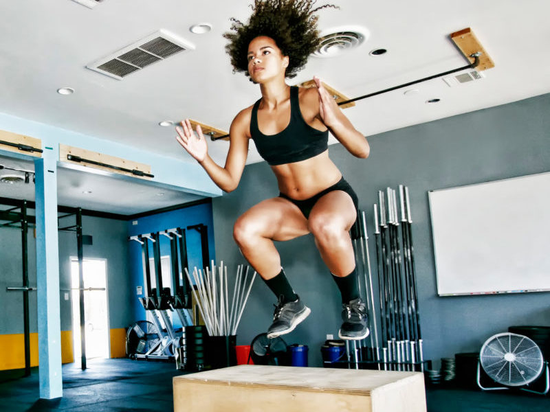 Woman working box jumps in a HIIT leg workout