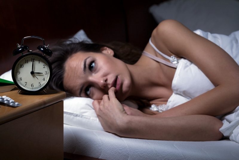 woman struggling to sleep as a pre-workout side effect