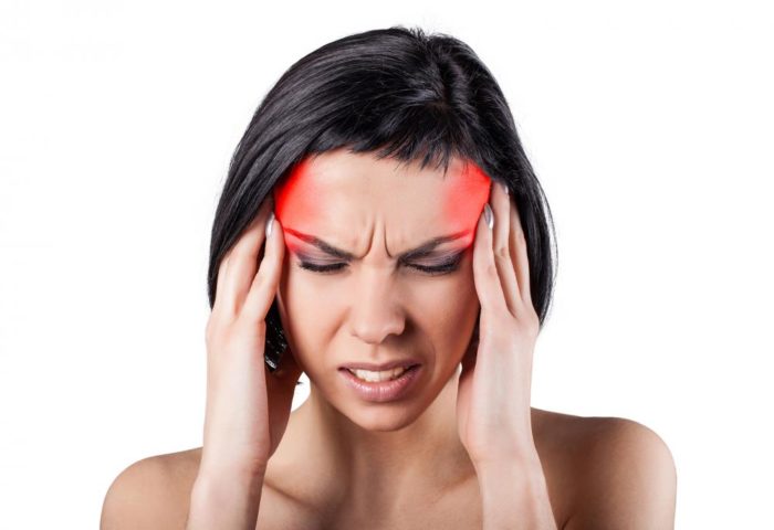 Woman holding her head because she has a headache