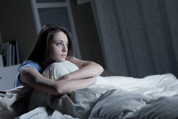 Woman struggling to sleep as part of a pre-workout side effect