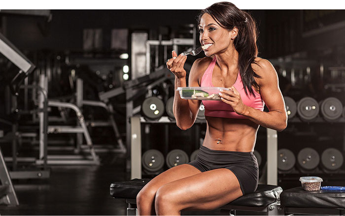 woman bodybuilder diet showing a woman sitting and eating a health meal looking lean and muscular